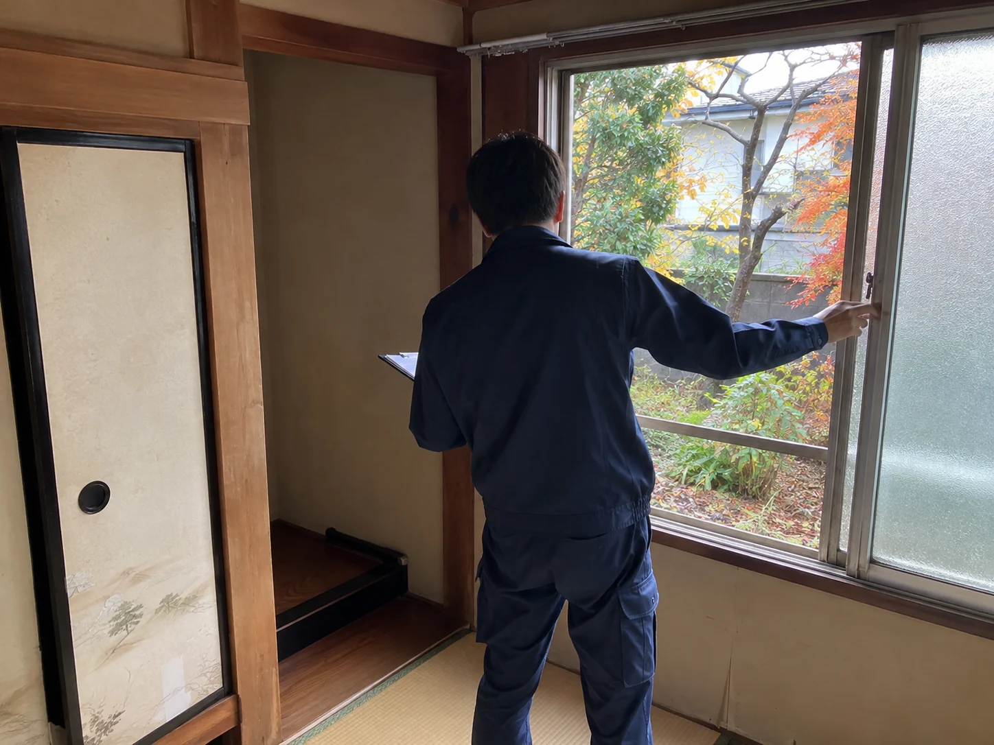 窓を開けて室内を確認する見回りスタッフの作業風景
